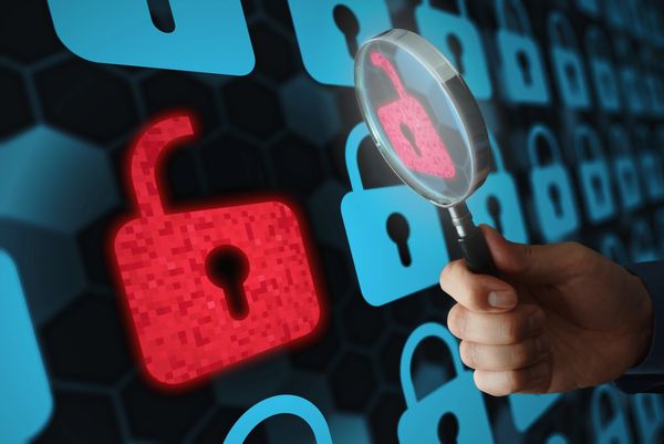 A red unlocked padlock highlighted with a magnifying glass among blue locked padlocks.