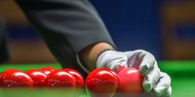 Snooker referee spotting the pink snooker ball.
