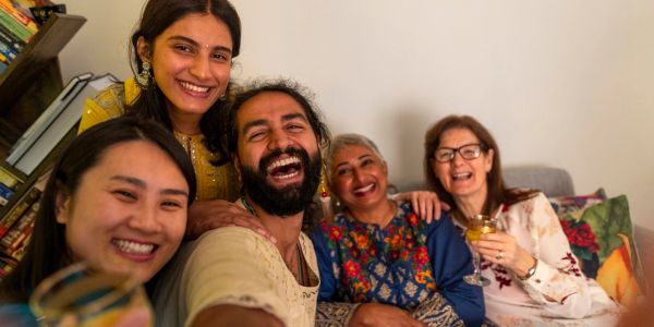 A diverse group of friends smiling and enjoying together indoors.