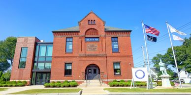 Historic red brick building with flags and clear blue sky.