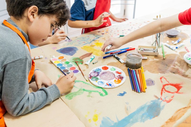 Child boy doing painting activity at school