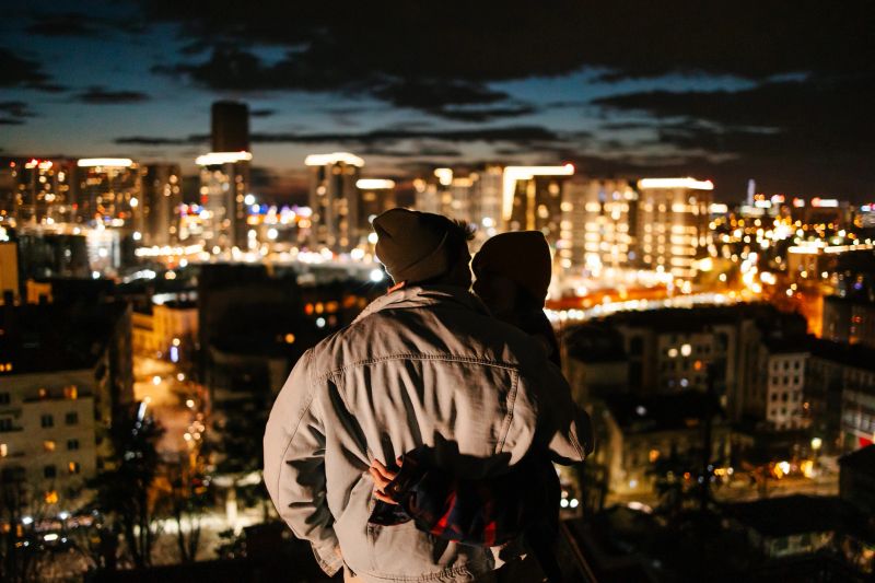 A couple hugging and admiring the night skyline
