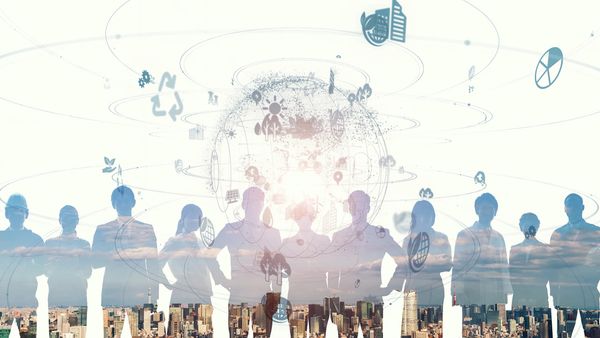 Silhouettes of people connected by digital icons over a cityscape background.