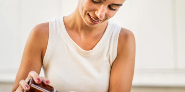 Woman smiling while pouring a drink from a bottle.