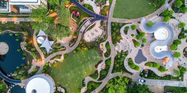 Aerial view of a vibrant park with winding pathways, greenery, and modern structures.