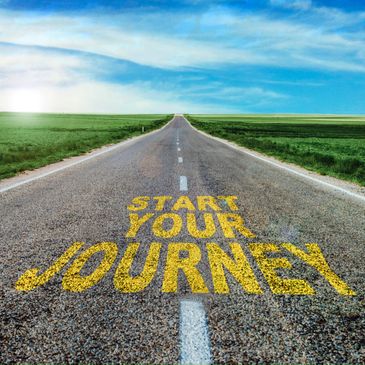 Open road with 'Start Your Journey' painted in yellow on the pavement.