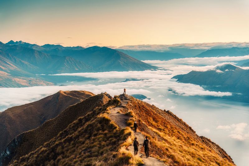 Landscape of Roys Peak summit with foggy mountain and tourist enjoying between Lake Wanaka and Glendhu Bay in autumn during the morning at New Zealand