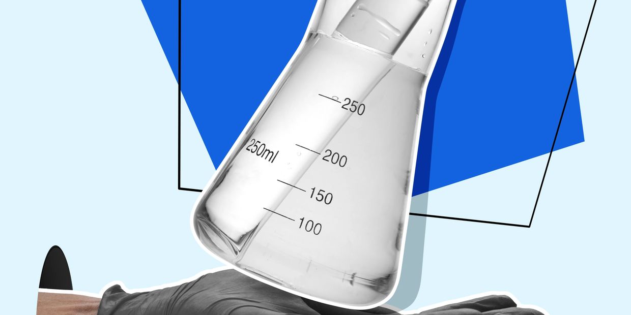 A gloved hand holding a 250ml laboratory flask with liquid inside.