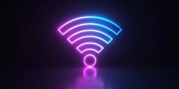 Glowing neon WiFi symbol in dark setting.
