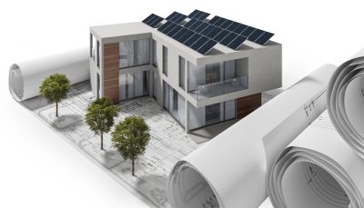 Modern house model with solar panels on blueprints.