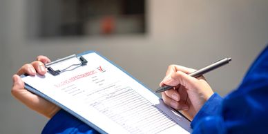 Close-up of hands holding a building inspection report on a clipboard.