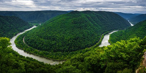 Scenic river winding through green forested hills.