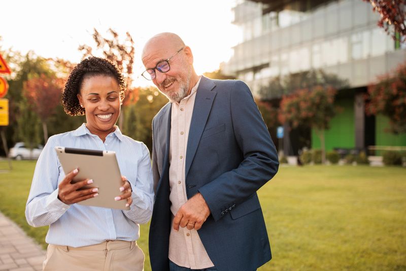 Two people having a business conversation outdoors in a business area ,with the office building in the background
