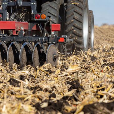 a tractor pulling a disc through a field