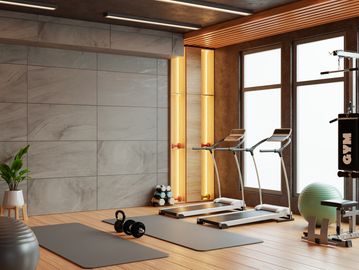 Modern home gym with treadmills and yoga mats by large windows.
