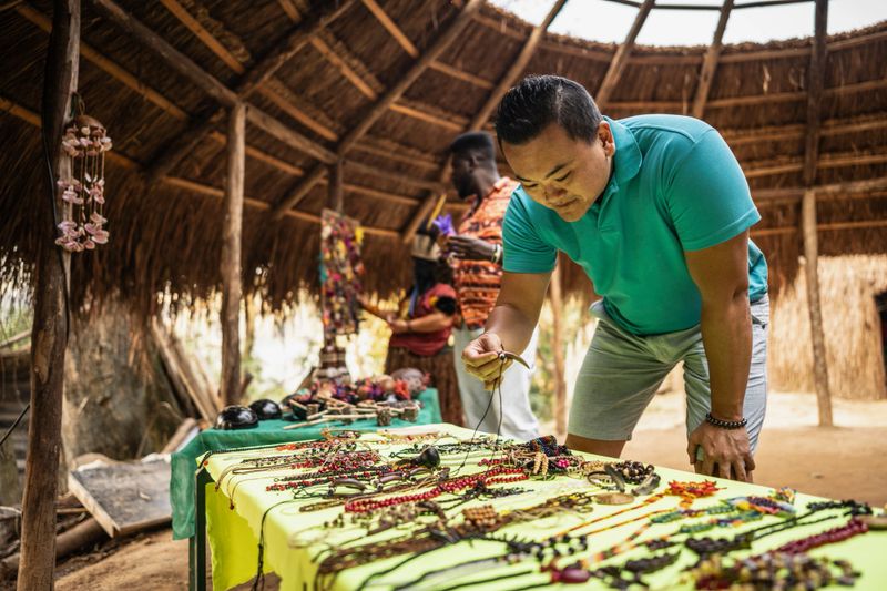 Tourist choosing indigenous souvenirs during visit to the Wassú Tribe