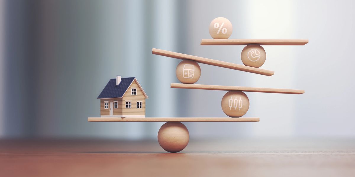 Model house balanced on wooden planks representing long-term property value