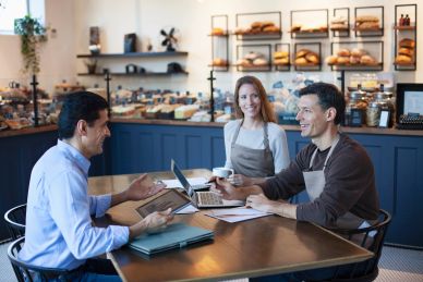 Three people meeting in a bakery.