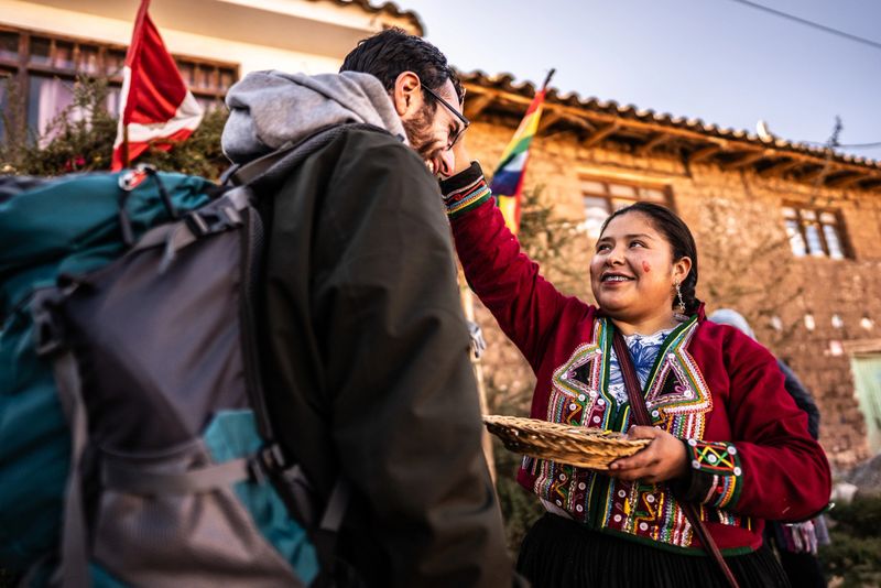 Chinchero indigenous women greeting tourist with flower petals, in Chinchero District