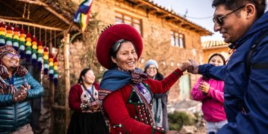 People joyfully dancing outdoors in traditional attire.