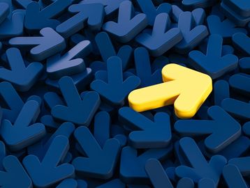 A yellow arrow pointing right among many blue arrows pointing down.