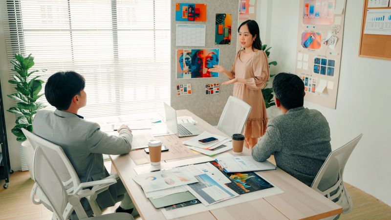 Team of Designers Discussing UX and UI Strategy in a Business Meeting with Creative Materials