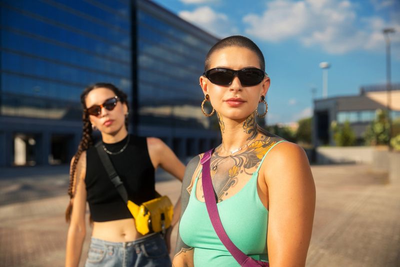Portrait of shaved girl looking at camera with other woman in the background blurred