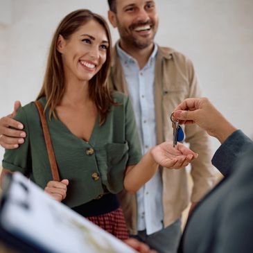 young couple holding keys to property 