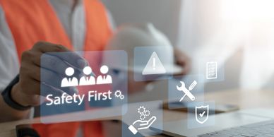 Person in safety vest interacting with virtual safety first icons near laptop.