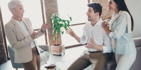 Business meeting with three people discussing ideas.