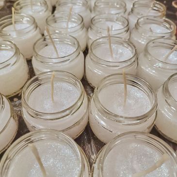 Rows of small glass jar candles.