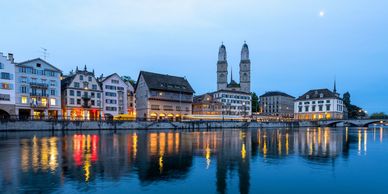 Zurich, Switzerland buildings at dusk from the river with a reflection.
