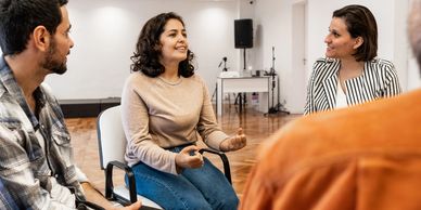 A woman speaking in a group setting.