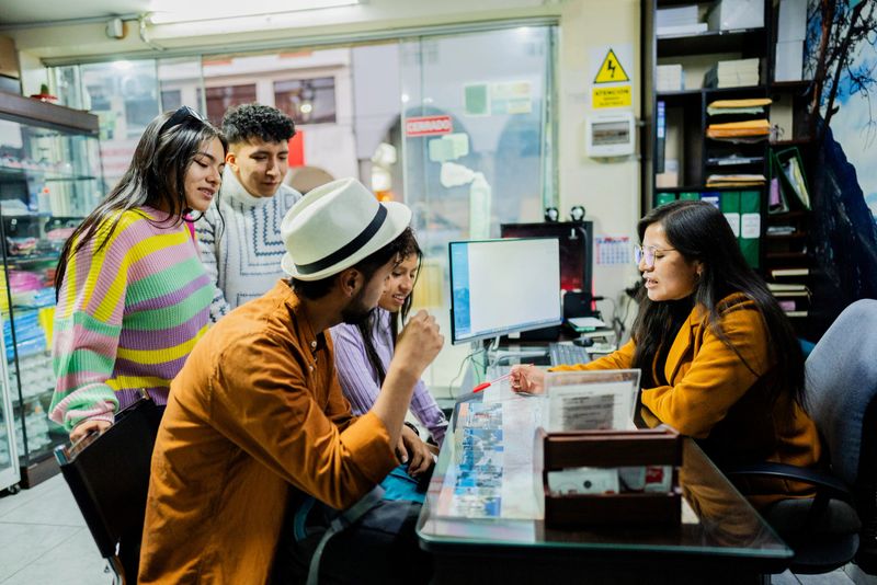 Tourist friends talking with a travel agent on a travel agency