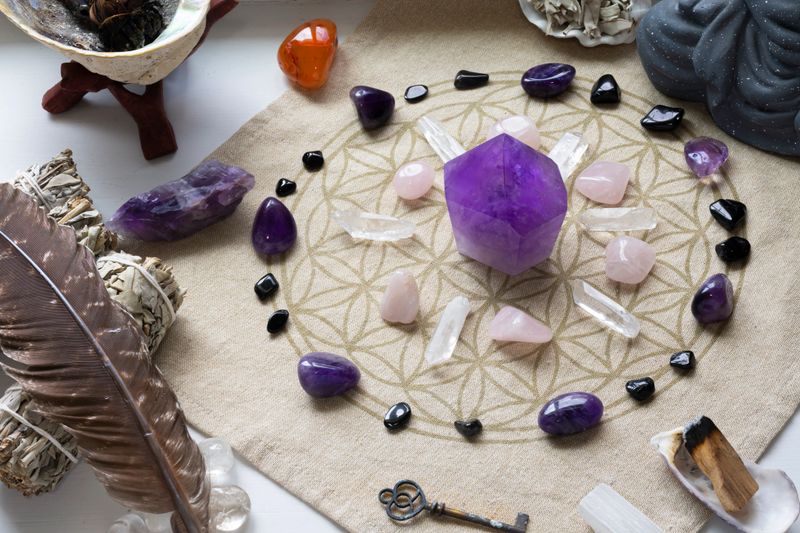 A top view image of a amethyst crystal healing grid with incense sticks.