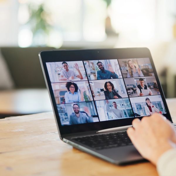 Virtual business meeting with diverse colleagues on a laptop screen.