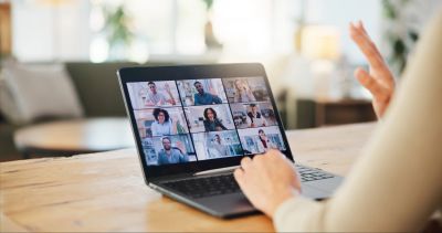 Person participating in a video call on a laptop.