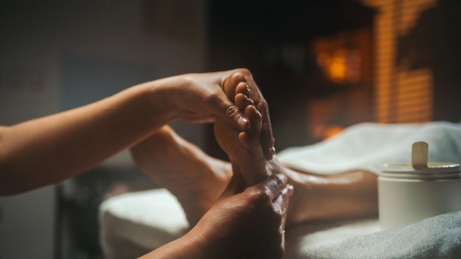Person receiving a relaxing foot massage in a cozy setting.