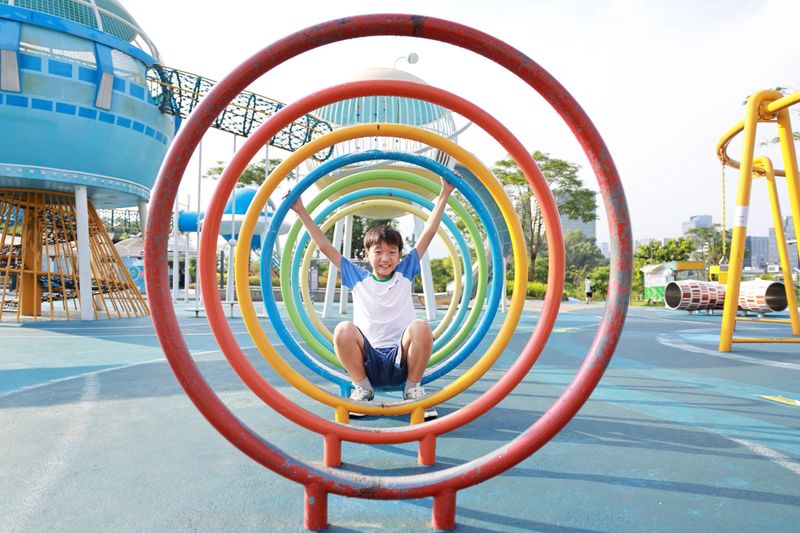 A joyful child playing in a colorful park, smiling at the camera.