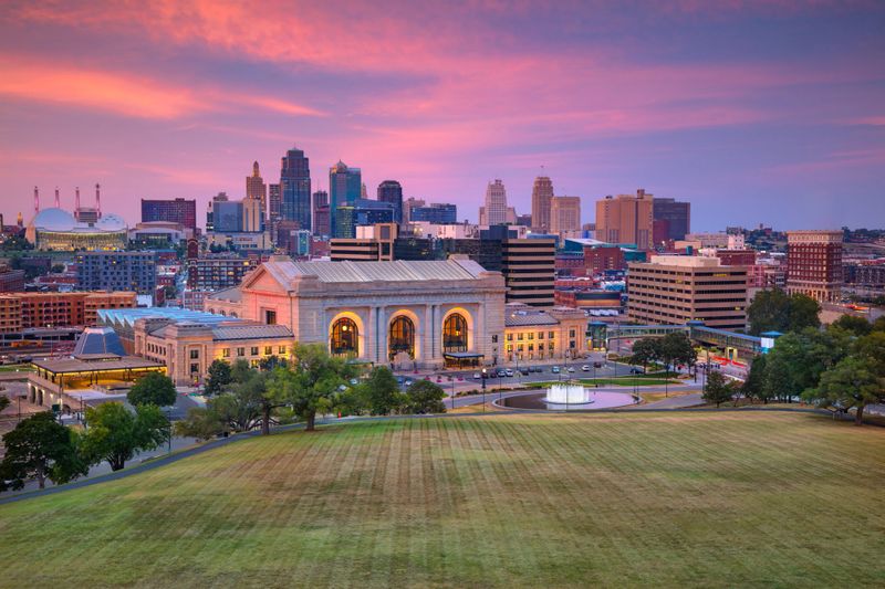 Aerial cityscape image of Kansas City skyline at autumn sunset.