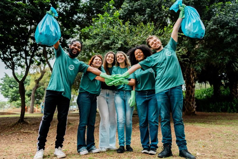 Portrait of a group of volunteers with hands stacked at public park