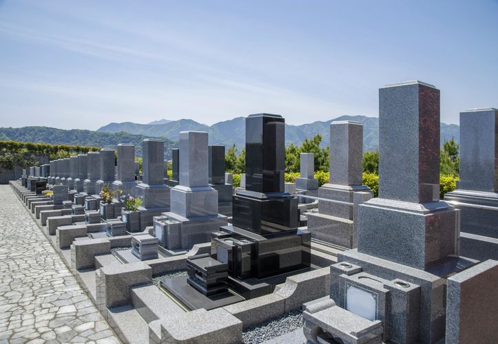 Black pencils in a gray holder next to a stack of white magazines with a camera in the background.