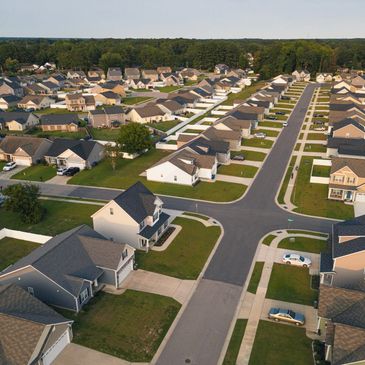 Aerial view of a suburban neighborhood with rows of houses and intersecting streets.
