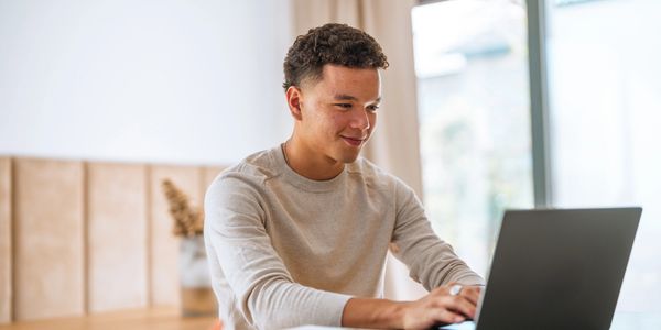 Young man working on laptop at home.