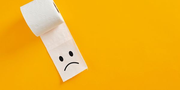 A toilet roll with a sad face.