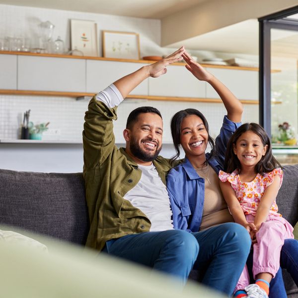 Happy family sitting on a couch, smiling and enjoying time together at home.