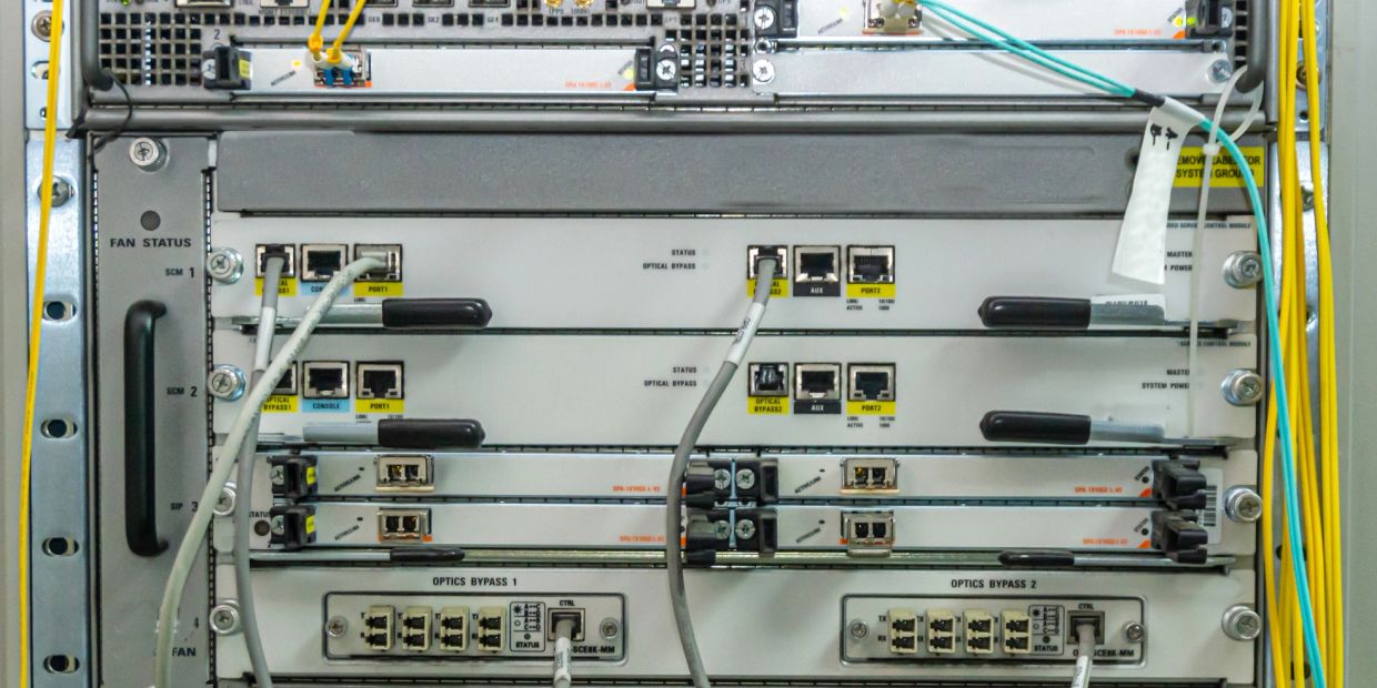 Network server rack with optical bypass modules and connected cables.