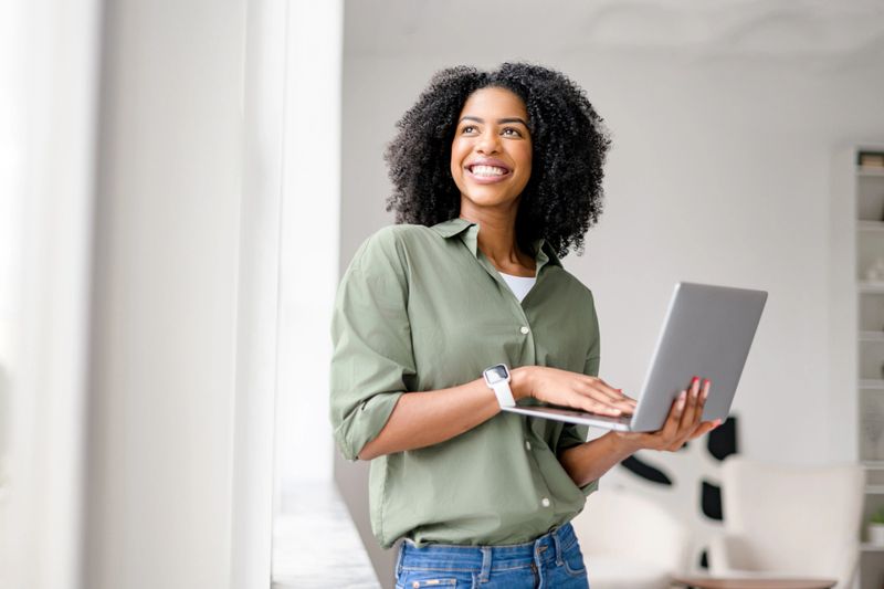 African-American woman enjoys her work on a laptop