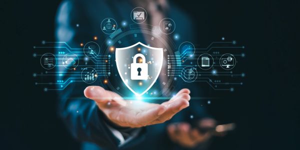 A businessman holding a digital shield with a lock symbolizing cybersecurity.