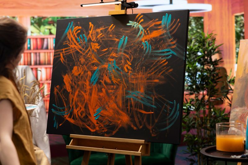 Skilled painter uses a variety of watercolor paint and finger painting technique to bring her abstract ideas to life. Creating a colorful artwork in a creative atelier, modern art.